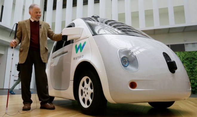 Steve Mahan, ancien directeur du Santa Clara Valley Blind Center, se tient à côté d'une voiture autonome Waymo mardi à San Francisco.