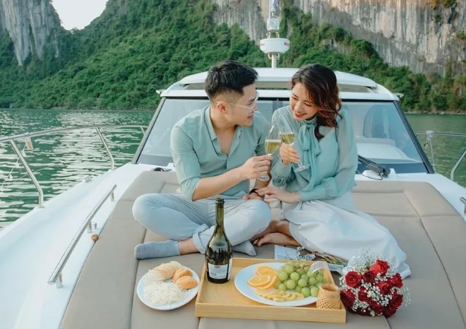 assis sur un grand bain de soleil à l'avant d'un Jeanneau NC14 dans la baie d'Halong