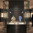 Vitrine d'exposition Audemars Piguet présentant deux montres historiques dans un espace muséal moderne à Singapour.