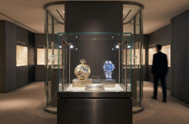 Vitrine d'exposition Audemars Piguet présentant deux montres historiques dans un espace muséal moderne à Singapour.