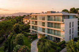 Résidence moderne de luxe entourée de jardins à Barcelone au coucher du soleil.