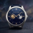 Montre de luxe Midnight Jour Nuit de Van Cleef & Arpels sur fond de nébuleuse étoilée.